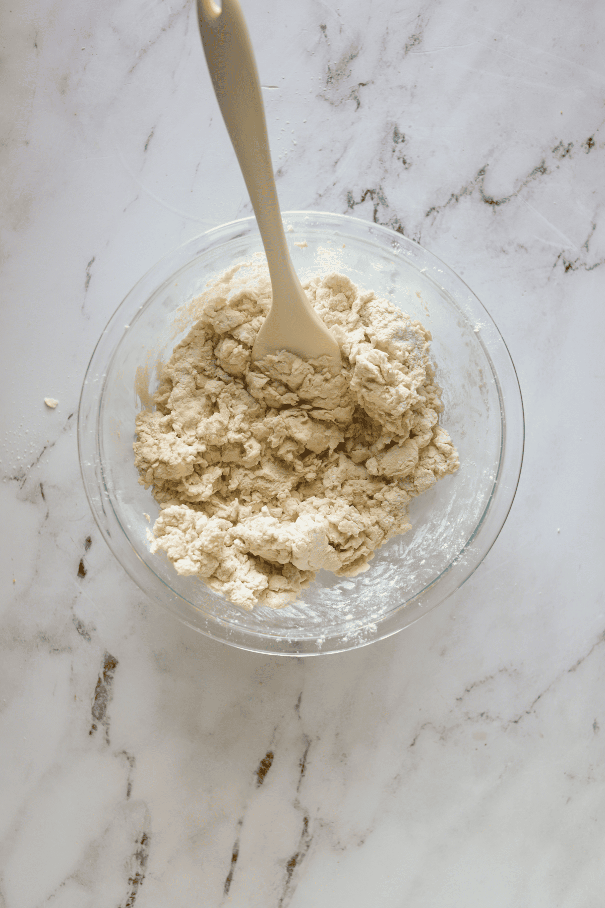 glass of bowl of drop biscuit dough with spatula in it