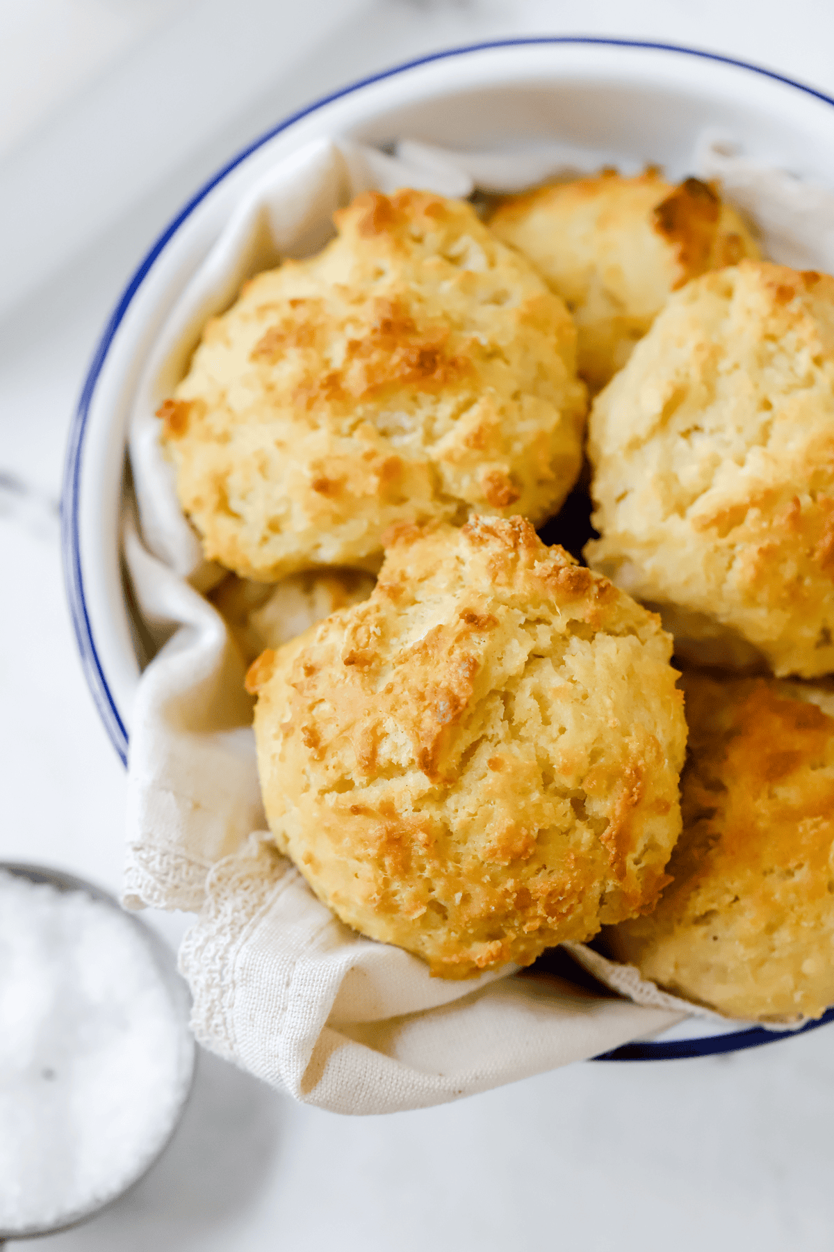Linen lined bowl filled with buttermilk drop biscuits
