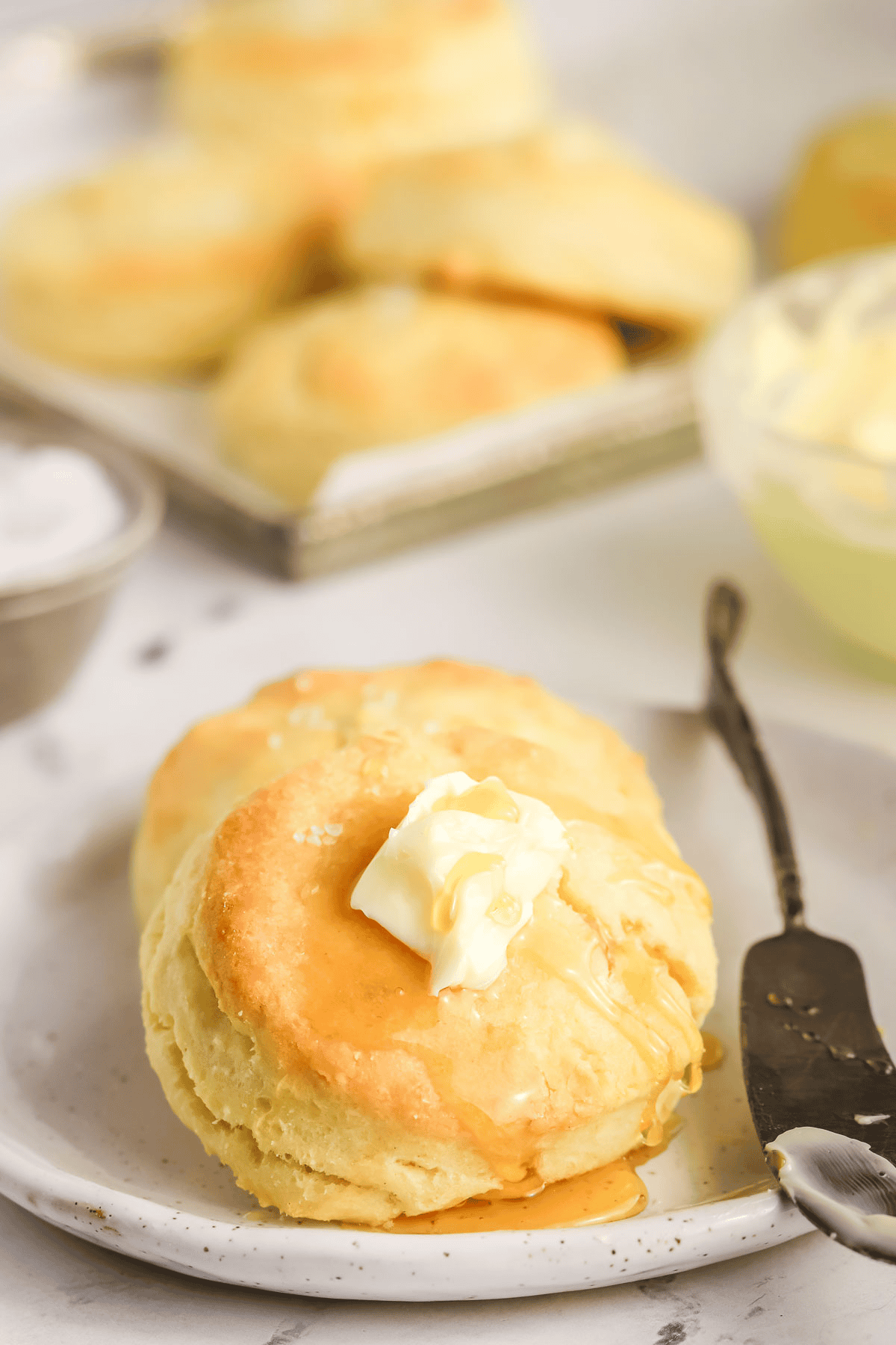 cream biscuit on a plate topped with butter