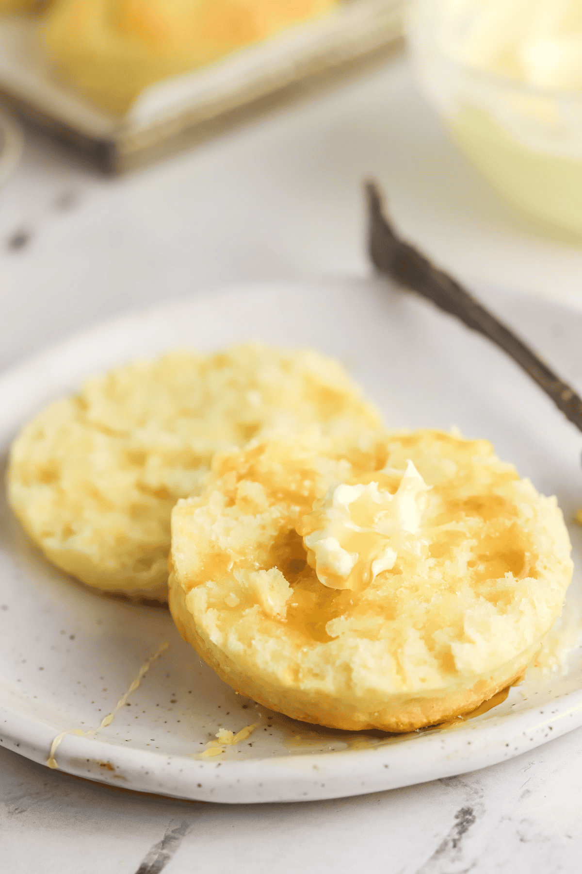 cream biscuit cut open topped with honey and butter