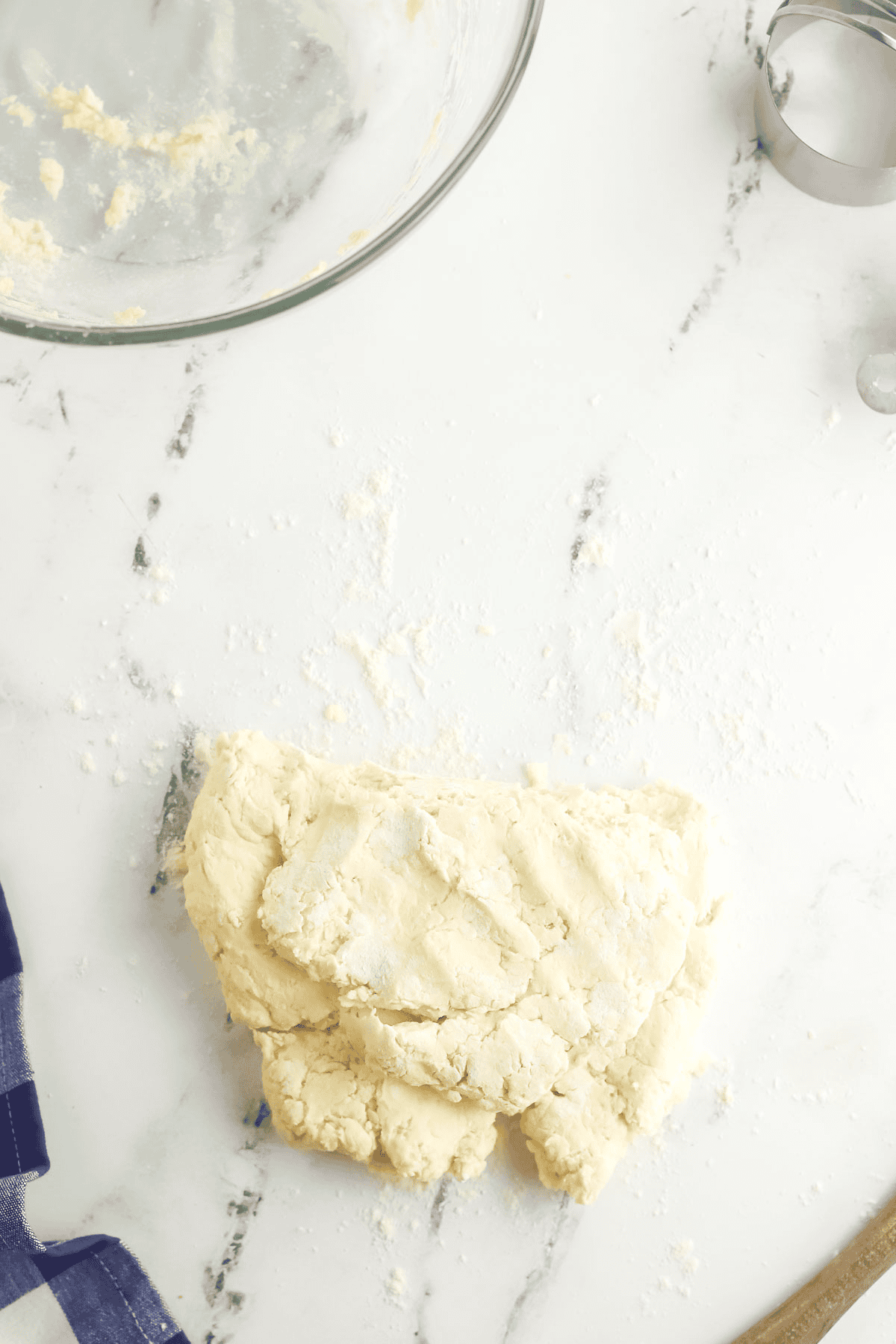 cream biscuit dough being folded in half