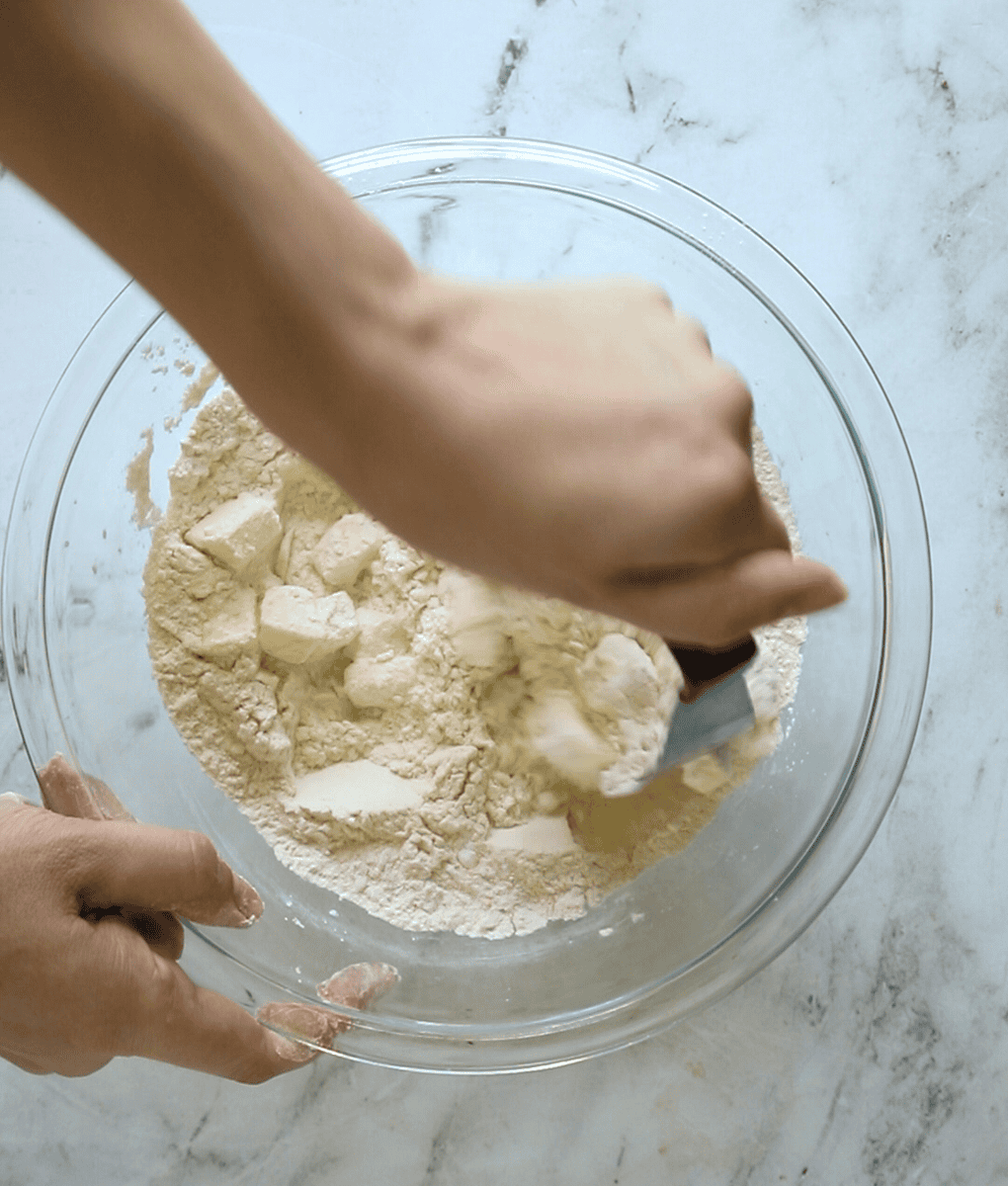 pastry cutter cutting cold butter into biscuit dry ingredients
