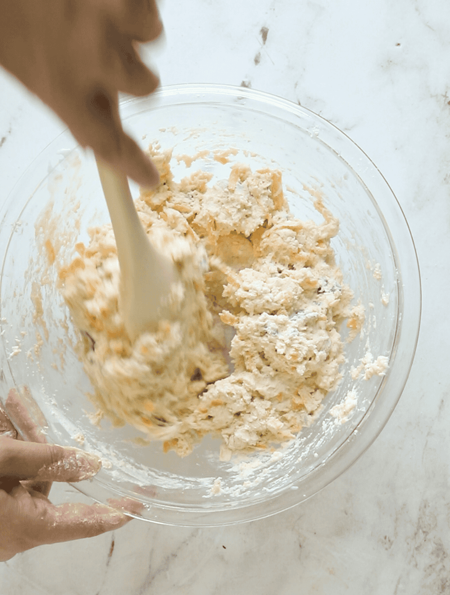 buttermilk being stirred into biscuit dough