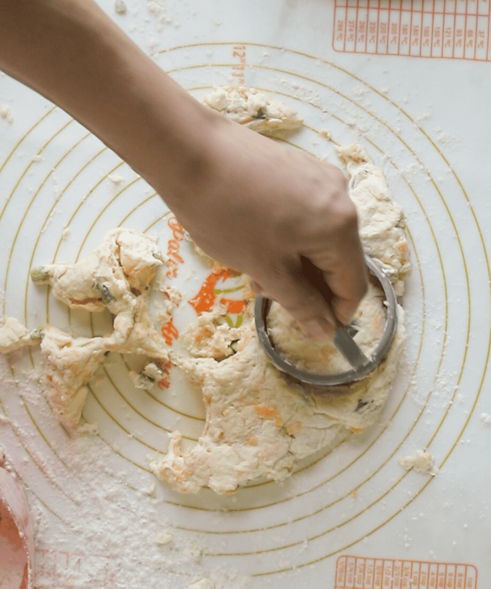 hand cutting biscuits out of dough