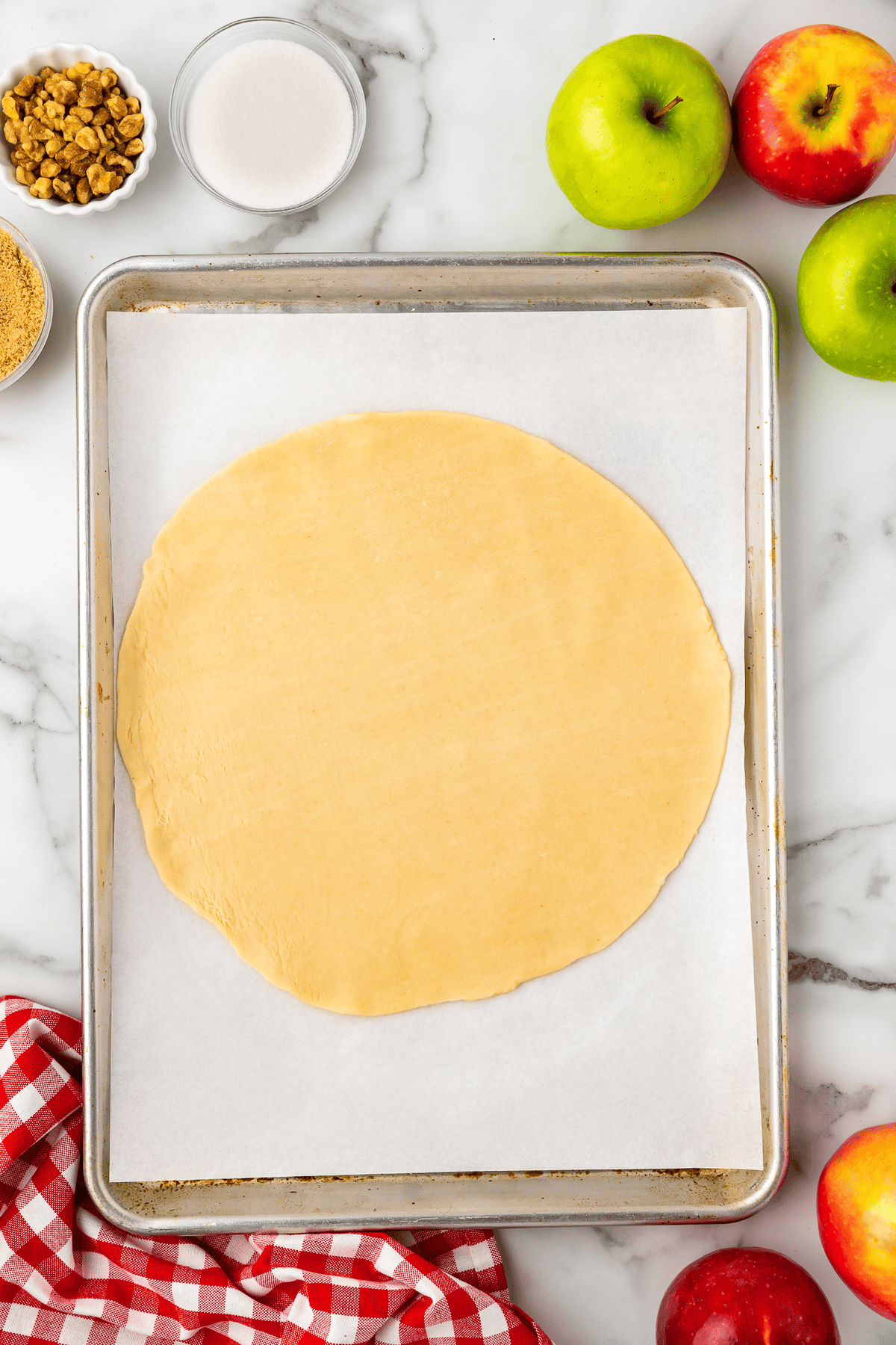 pie dough rolled out into a circle on a baking sheet lined with parchment paper