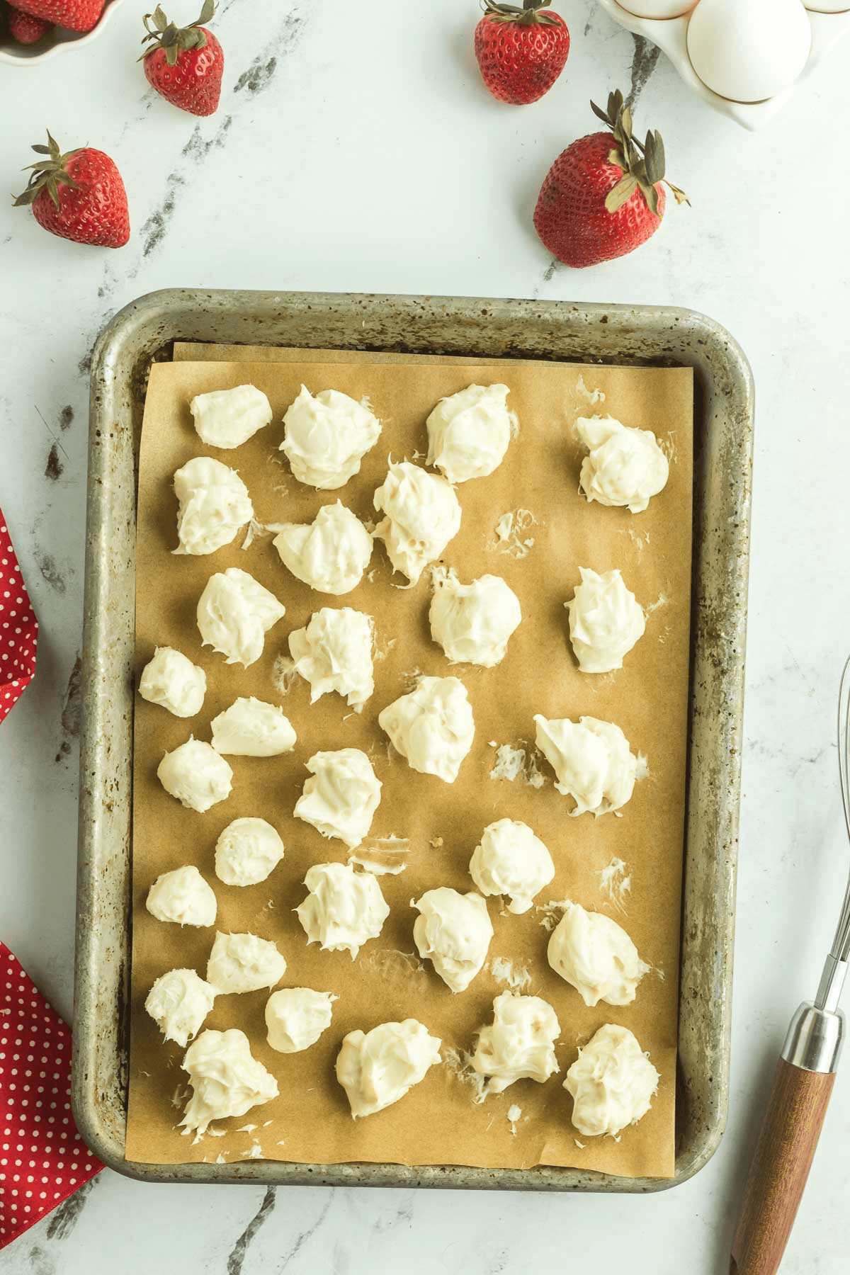 cream cheese balls on parchment lined cookie sheet