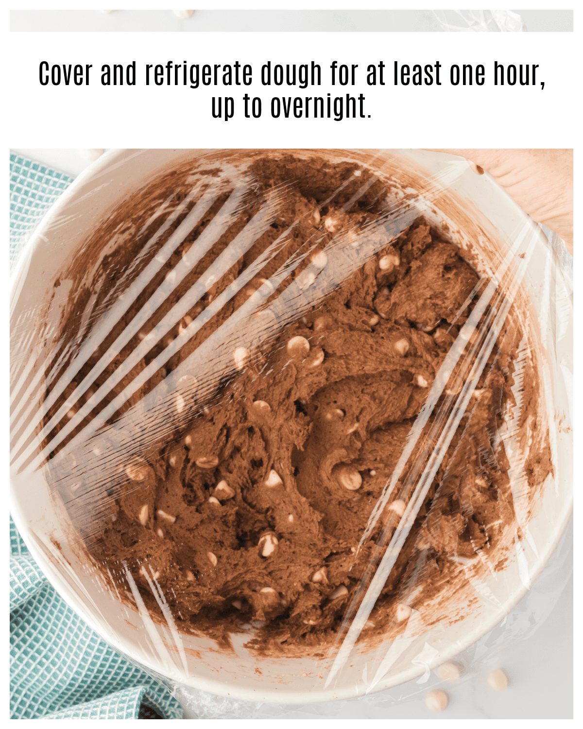 bowl of chocolate white chocolate chip cookies dough covered with plastic wrap