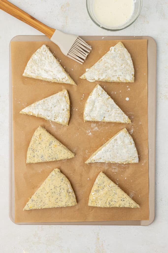 lemon poppyseed scones cut into 8 wedges and brushed with heavy cream