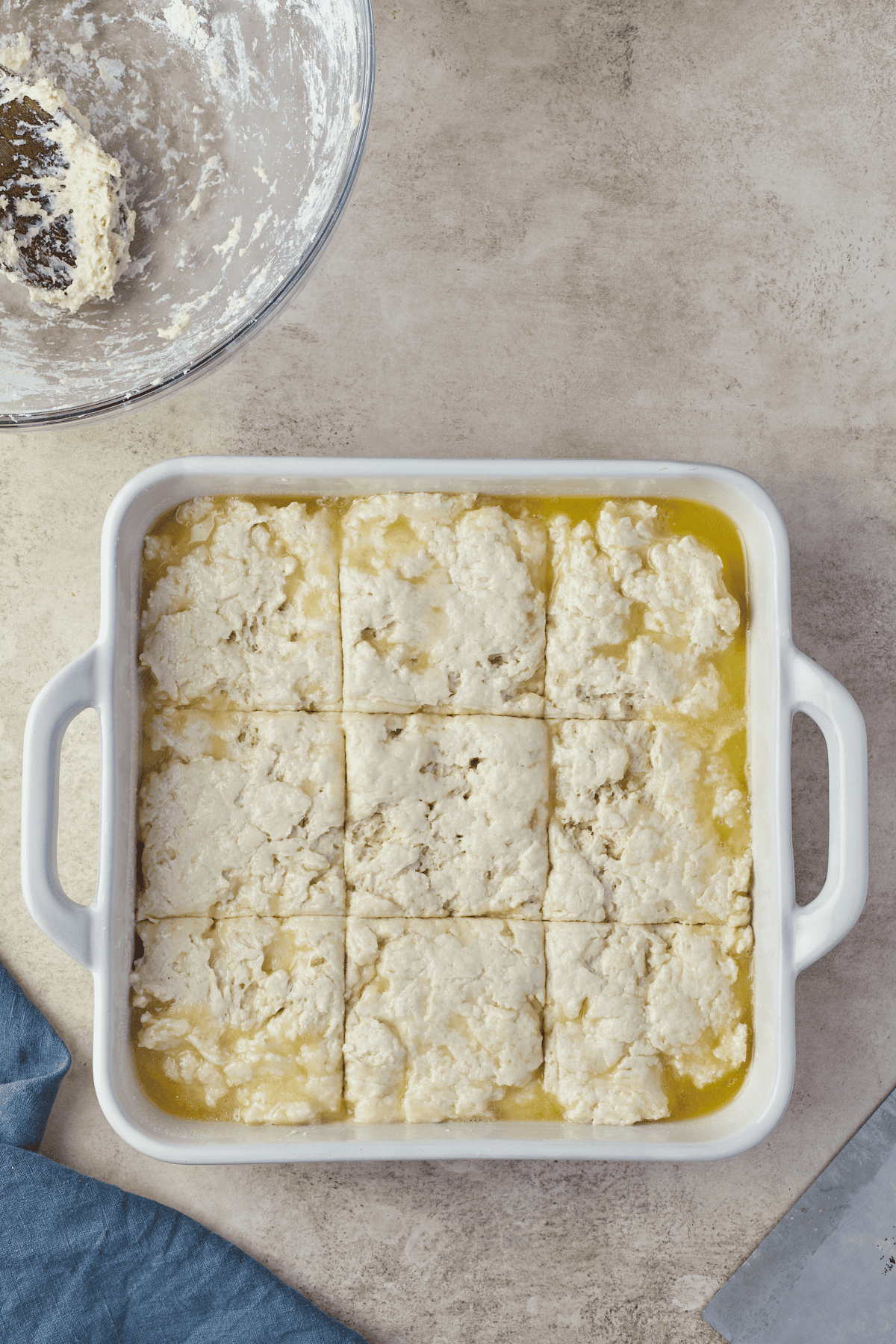 unbaked dough in pan marked with lines on top in a baking dish
