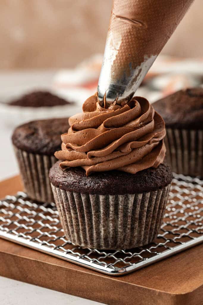 chocolate frosting piped onto a chocolate cupcake