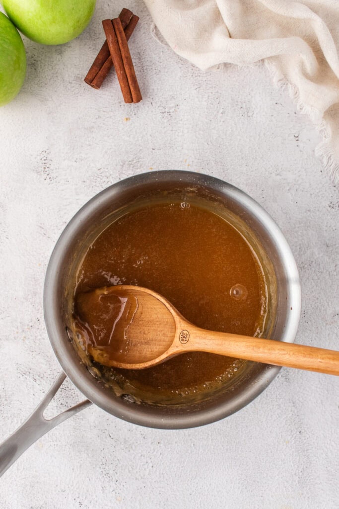brown sugar and butter mixture in a saucepan with a wooden spoon