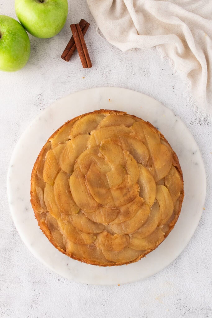 whole apple upside-down cake on a serving plate