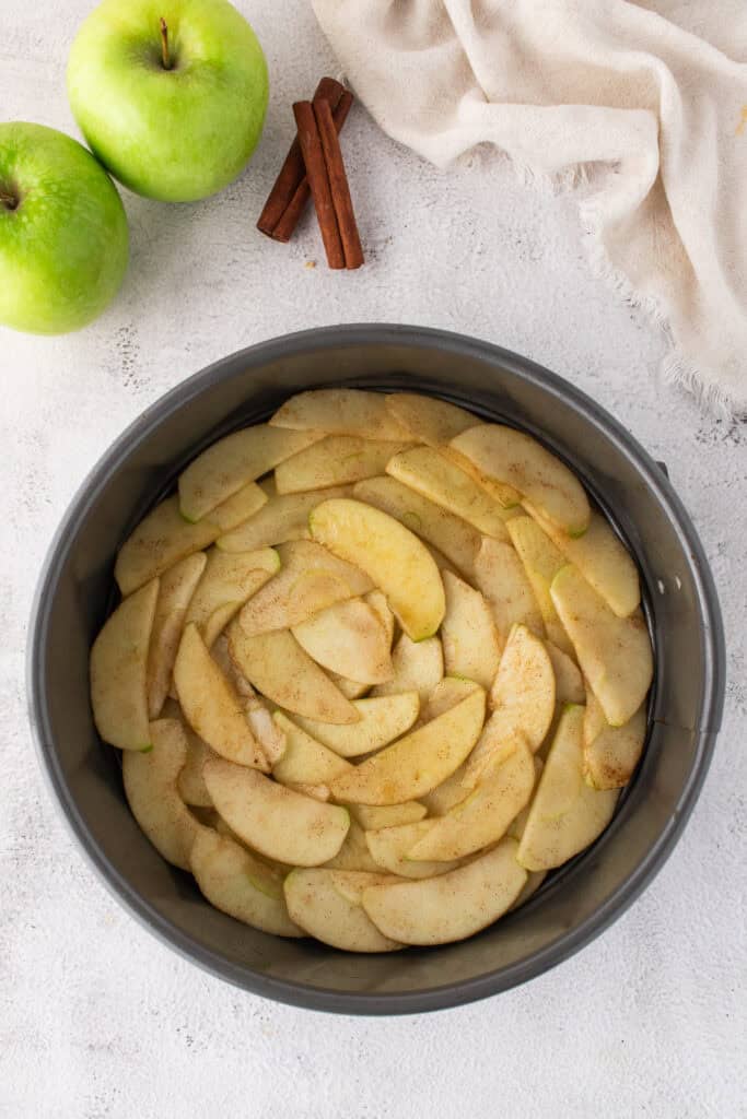 apples arranged in bottom of the cake pan